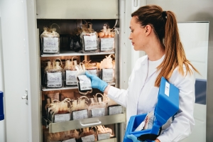 Woman taking out blood bags from a blood bank refrigerator