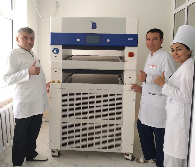 Navoi Region Blood Transfusion Station staff posing with a blood plasma Contact-Shock Freezer (CSF61) from B Medical Systems.